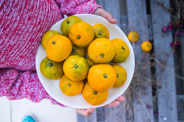 Young girl holds homegrown tangerines.