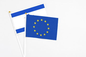 European Union and Israel stick flags on white background. High quality fabric, miniature national flag. Peaceful global concept.White floor for copy space.