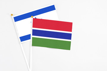 Gambia and Israel stick flags on white background. High quality fabric, miniature national flag. Peaceful global concept.White floor for copy space.