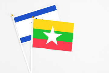 Myanmar and Israel stick flags on white background. High quality fabric, miniature national flag. Peaceful global concept.White floor for copy space.