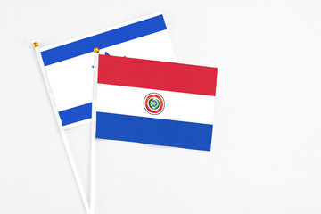 Paraguay and Israel stick flags on white background. High quality fabric, miniature national flag. Peaceful global concept.White floor for copy space.