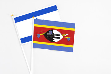 Swaziland and Israel stick flags on white background. High quality fabric, miniature national flag. Peaceful global concept.White floor for copy space.