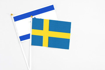 Sweden and Israel stick flags on white background. High quality fabric, miniature national flag. Peaceful global concept.White floor for copy space.