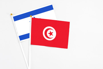 Tunisia and Israel stick flags on white background. High quality fabric, miniature national flag. Peaceful global concept.White floor for copy space.