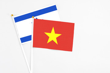 Vietnam and Israel stick flags on white background. High quality fabric, miniature national flag. Peaceful global concept.White floor for copy space.