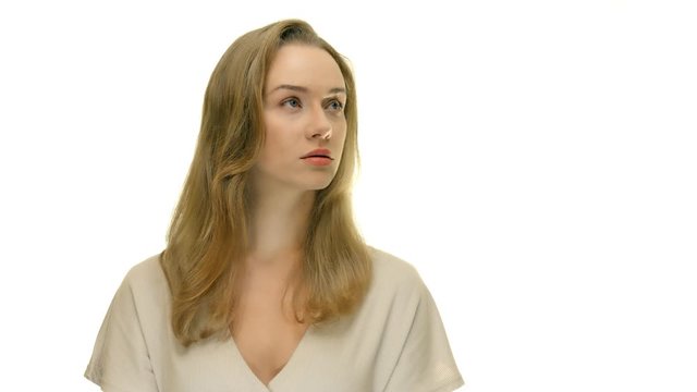 Seriouse woman looking to the right upper side and than straight to the camera. Studio portrait.