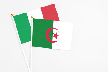 Algeria and Italy stick flags on white background. High quality fabric, miniature national flag....