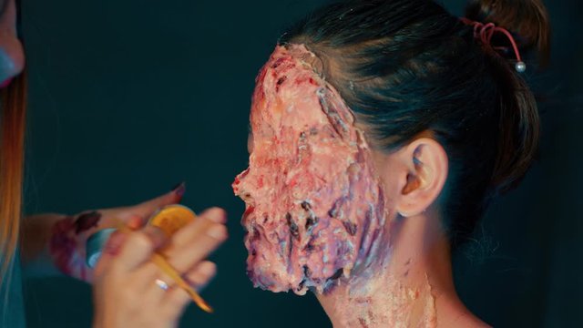 Disgusting horror flesh blood gore prosthetic on a female, extreme closeup shot