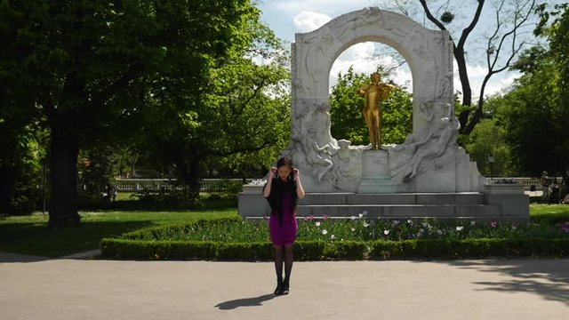 Asian Woman Posing Standing in Front of Strauss Statue Playing with her Hair - Slow Motion