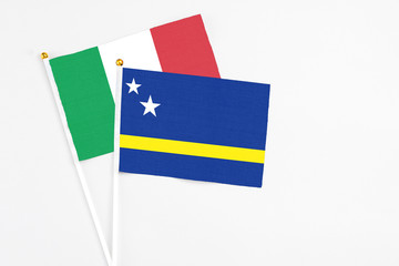 Curacao and Italy stick flags on white background. High quality fabric, miniature national flag. Peaceful global concept.White floor for copy space.