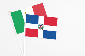 Dominican Republic and Italy stick flags on white background. High quality fabric, miniature national flag. Peaceful global concept.White floor for copy space.