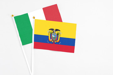 Ecuador and Italy stick flags on white background. High quality fabric, miniature national flag. Peaceful global concept.White floor for copy space.