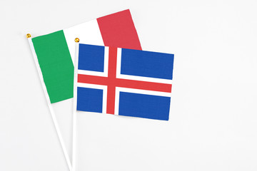 Iceland and Italy stick flags on white background. High quality fabric, miniature national flag. Peaceful global concept.White floor for copy space.