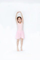 Asian little child girl dancer ballet ballerina stretching isolated on white background. Beautiful children in pink tutu skirt.
