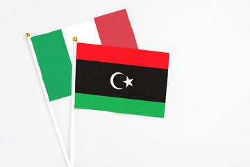 Libya and Italy stick flags on white background. High quality fabric, miniature national flag....