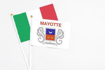 Mayotte and Italy stick flags on white background. High quality fabric, miniature national flag. Peaceful global concept.White floor for copy space.