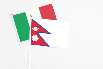 Fototapeta na wymiar Nepal and Italy stick flags on white background. High quality fabric, miniature national flag. Peaceful global concept.White floor for copy space.