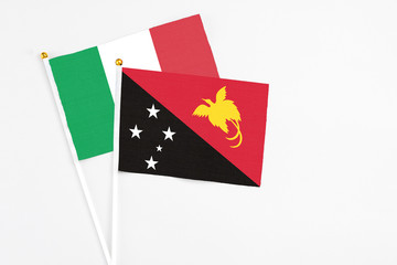 Papua New Guinea and Italy stick flags on white background. High quality fabric, miniature national flag. Peaceful global concept.White floor for copy space.