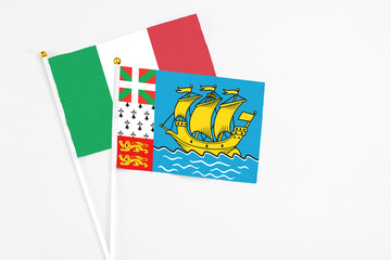 Saint Pierre And Miquelon and Italy stick flags on white background. High quality fabric, miniature national flag. Peaceful global concept.White floor for copy space.