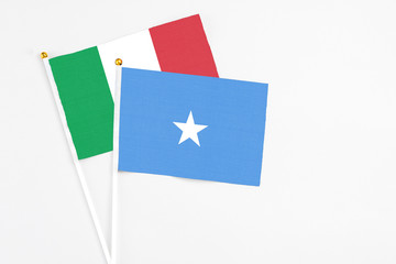 Somalia and Italy stick flags on white background. High quality fabric, miniature national flag. Peaceful global concept.White floor for copy space.