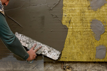 Plastrerer man plastering mineral wool slabs (rock wool, mineral cotton) insulation with...