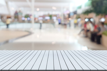 White wooden table with shopping mall blurred background