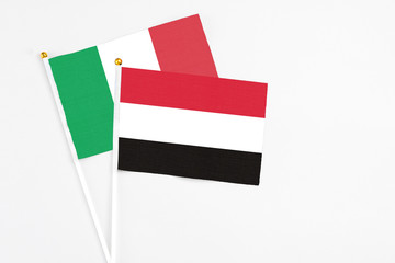 Yemen and Italy stick flags on white background. High quality fabric, miniature national flag. Peaceful global concept.White floor for copy space.