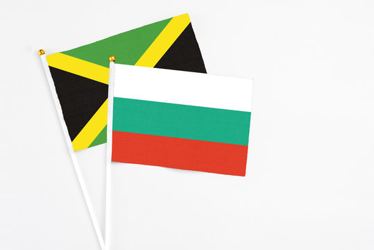 Bulgaria and Jamaica stick flags on white background. High quality fabric, miniature national flag. Peaceful global concept.White floor for copy space.