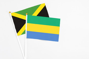 Gabon and Jamaica stick flags on white background. High quality fabric, miniature national flag....
