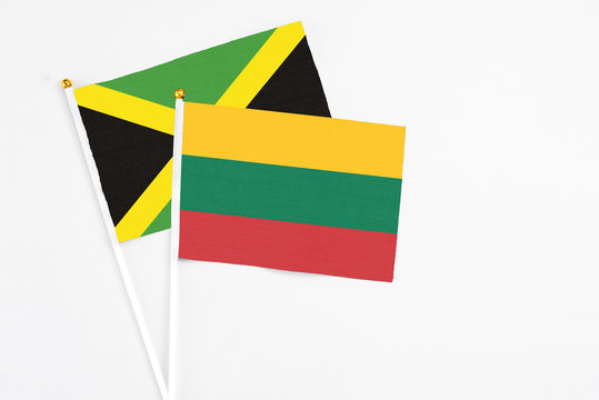 Lithuania and Jamaica stick flags on white background. High quality fabric, miniature national flag. Peaceful global concept.White floor for copy space.