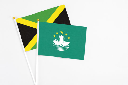 Macao and Jamaica stick flags on white background. High quality fabric, miniature national flag. Peaceful global concept.White floor for copy space.