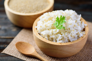 Cooked rice with quinoa seed in bowl on wooden background