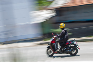 Motion Blurred panning photo of Unidentified name people riding motorcycle