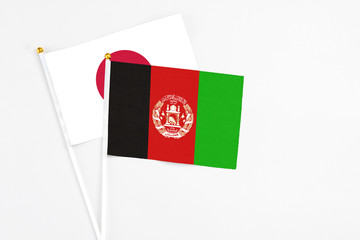 Afghanistan and Japan stick flags on white background. High quality fabric, miniature national...