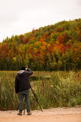 Man Taking Photographs of Trees in the Fall