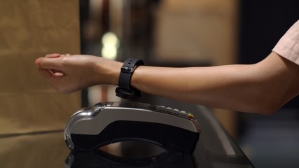 Young woman smart watch contactless payment in shop