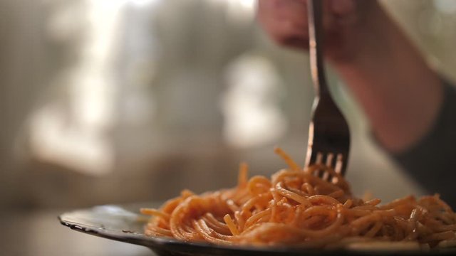 woman eating pasta with a fork, close up