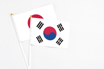 South Korea and Japan stick flags on white background. High quality fabric, miniature national flag. Peaceful global concept.White floor for copy space.