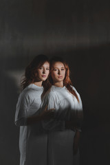 Studio portrait of two red-haired twin girls.