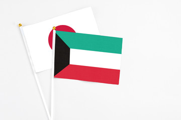 Kuwait and Japan stick flags on white background. High quality fabric, miniature national flag. Peaceful global concept.White floor for copy space.