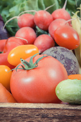 Fresh ripe vegetables in wooden box as healthy snack containing vitamins