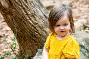 child sitting by tree