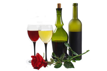Two glasses of white and red wine, a large bottle and a rose on white. Isolated on white.