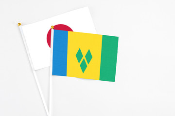 Saint Vincent And The Grenadines and Japan stick flags on white background. High quality fabric,...