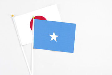 Somalia and Japan stick flags on white background. High quality fabric, miniature national flag. Peaceful global concept.White floor for copy space.