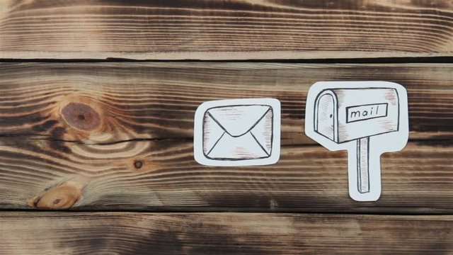 Paper drawing sketches with mail-themed letters on wooden