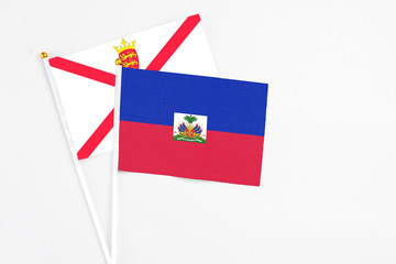 Haiti and Jersey stick flags on white background. High quality fabric, miniature national flag....