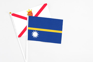 Nauru and Jersey stick flags on white background. High quality fabric, miniature national flag. Peaceful global concept.White floor for copy space.