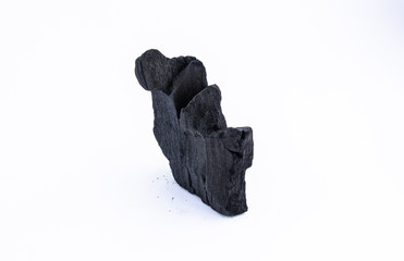 black coal on a white background. a porous black solid consisting of an amorphous form of carbon,...