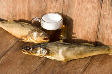 Oktoberfest holiday concept. Smoked fish and a glass of beer. Cold smoked pike perch on a dark...